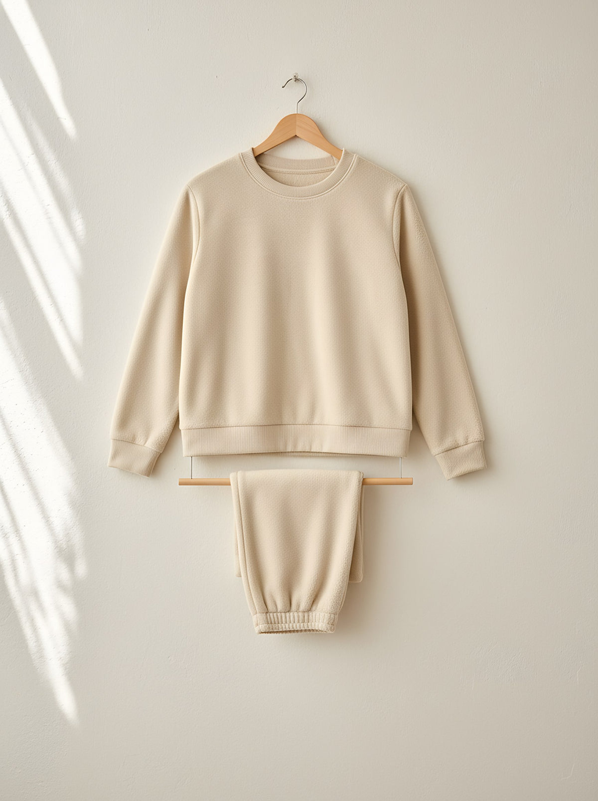 Marigold warm fleece pyjamas, front view on a wooden hanger, Cedar Atelier